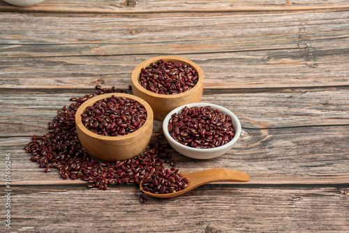 Red kidney beans in white cup and wood cup on wooden background