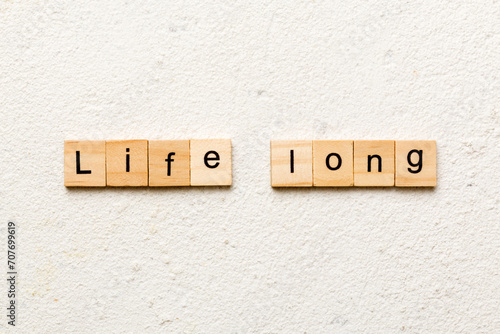 life long word written on wood block. life long text on table, concept photo