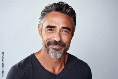 Handsome mature man. Portrait of a handsome mature man smiling and looking at camera while standing against grey background