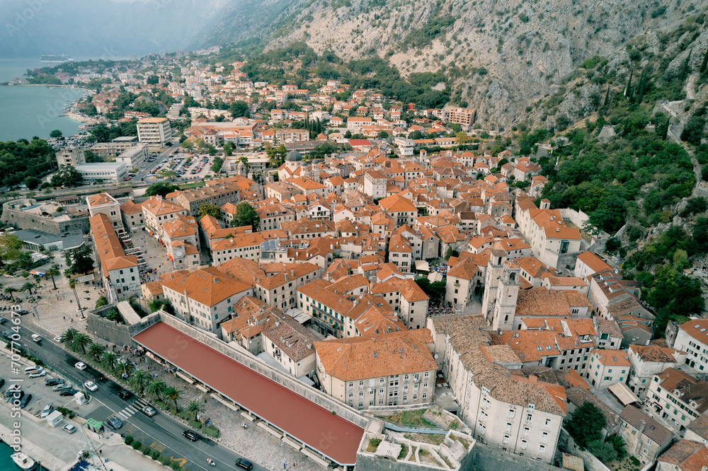 Embankment of the ancient town of Kotor at the foot of the mountains. Montenegro. Aerial view