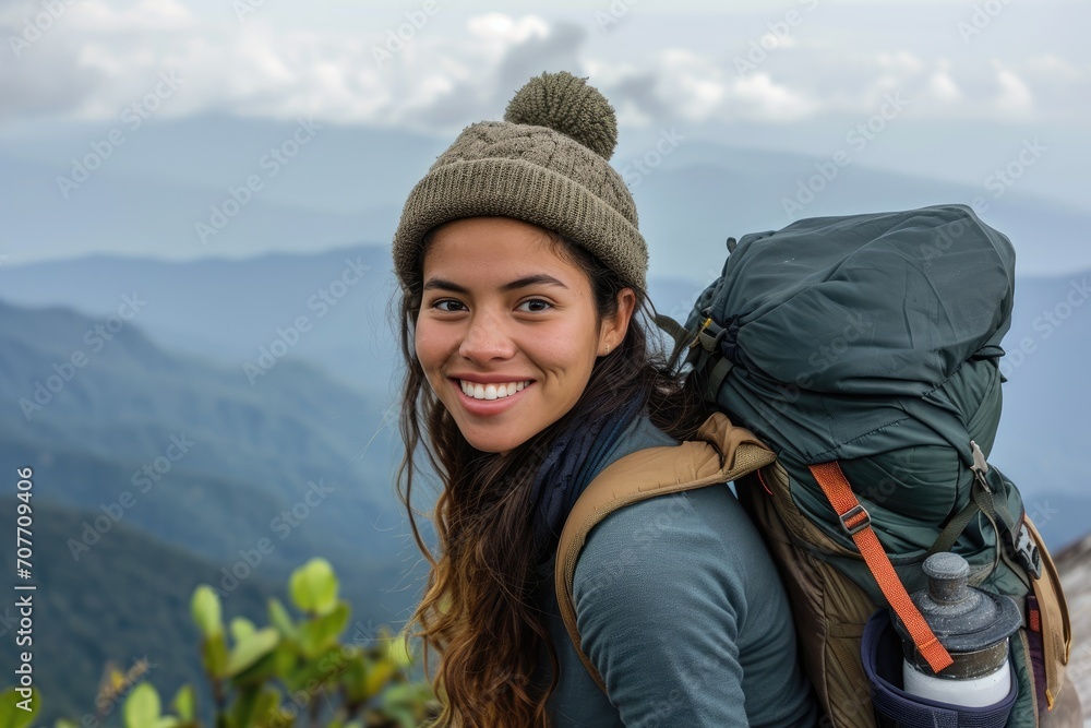 Adventurous studio portrait of a young Latina woman in hiking gear, with a backpack, isolated on a mountain landscape background Adventurous studio portrait of a young Latina woman in hiking gear, with a backpack, isolated on a mountain landscape background