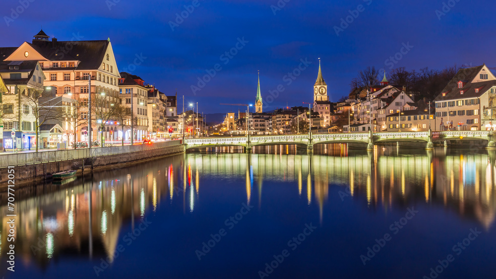 Night cityscape with Limmat river of the historical Zurich city, Switzerland.Panoramic view of historic Zurich city center with famous Fraumunster Church and river Limmat at Lake Zurich ,in twilight.