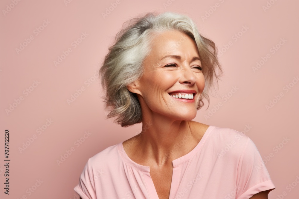 Portrait of a smiling senior woman with grey hair on a pink background Portrait of a smiling senior woman with grey hair on a pink background