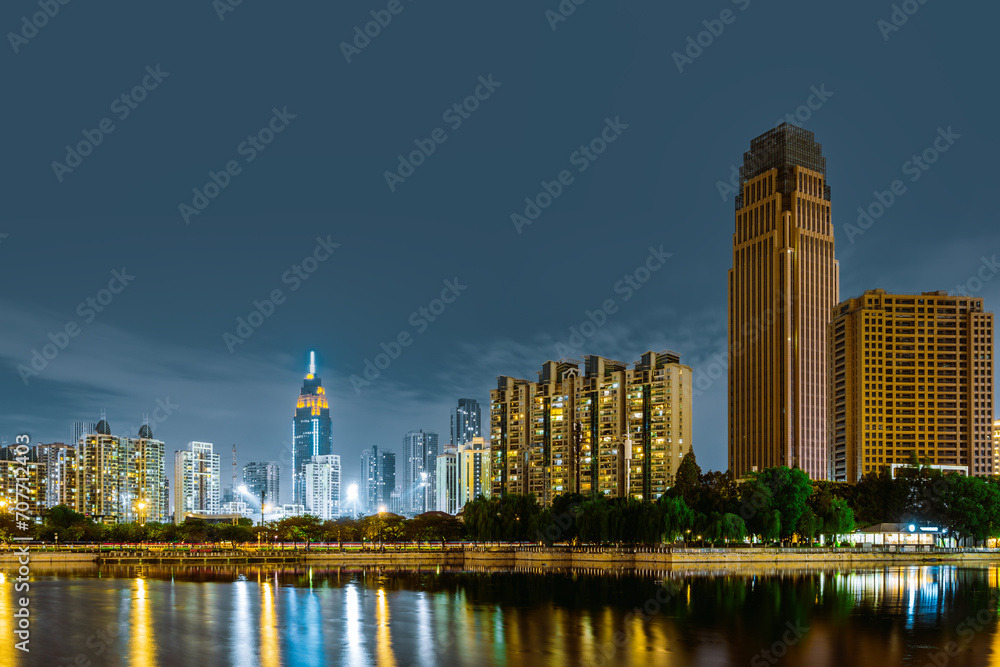 Naklejka premium Skyscrapers by the lake, night view of Wuhan, China.
