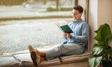 Focused calm smart european young man student in glasses read book, enjoy peace