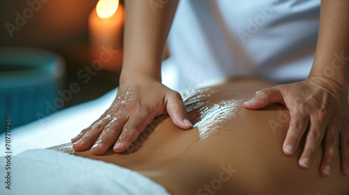 Close-up of young woman having back massage in spa salon.