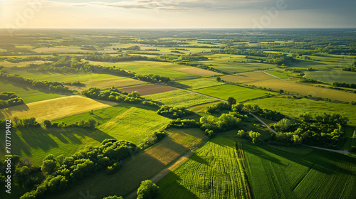 Aerial view of a sprawling agricultural landscape with patchwork fields and winding country roads.
