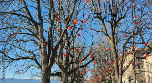 Tree path with garland of red flowers in Geneva, Switzerland, Europe