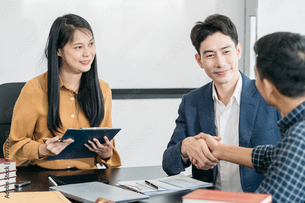 Lawyer shaking hands with client after discussing final contract agreement. Lawyer shaking hands with client after discussing final contract agreement.
