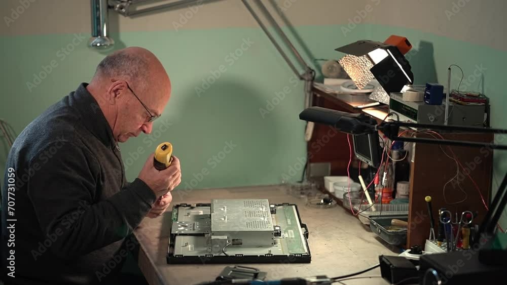 assemble the disassembled monitor. an elderly man works in a repair shop. Monitor repair. disassembled monitor. High quality video in 4k assemble the disassembled monitor. an elderly man works in a repair shop. Monitor repair. disassembled monitor. High quality video in 4k