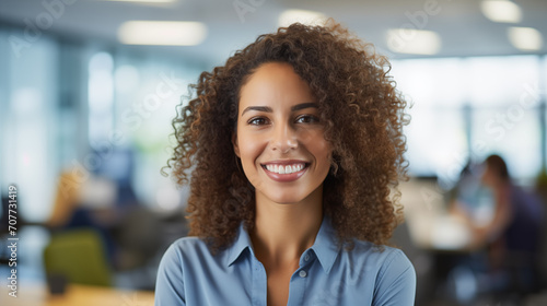 The image is of a confident professional woman smiling in an office setting.