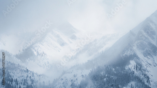 A blizzard covering a mountain range with heavy snowfall strong winds and obscured peaks.