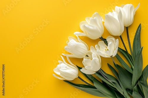 A bunch of white tulips on a yellow background.