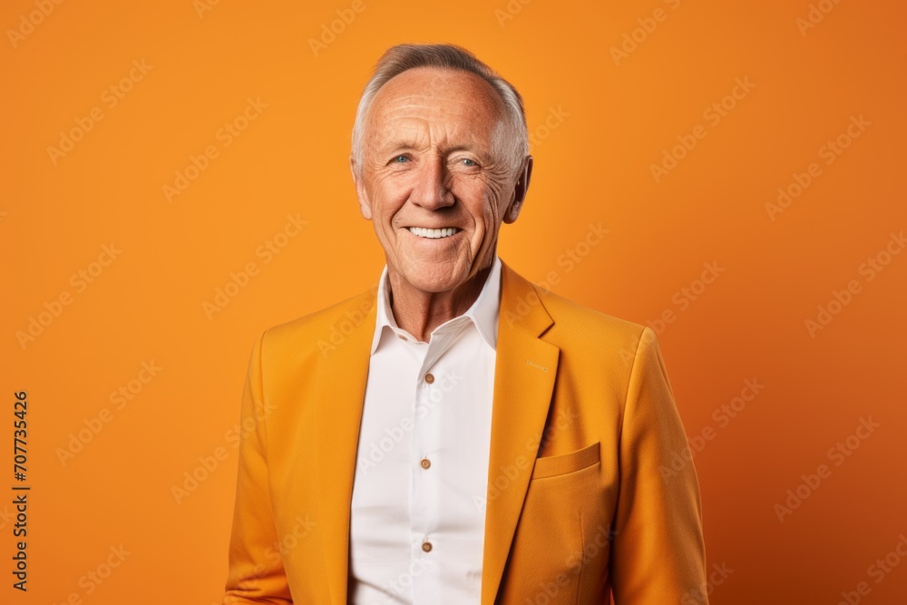 Portrait of a happy senior man in yellow jacket on orange background Portrait of a happy senior man in yellow jacket on orange background