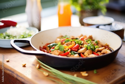 mid-stir kung pao chicken in skillet with vegetables