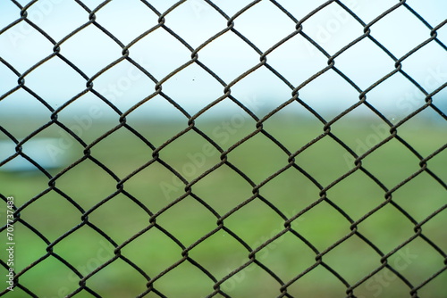 Chain link metal wire fence, close up shot, shallow depth of field, no people