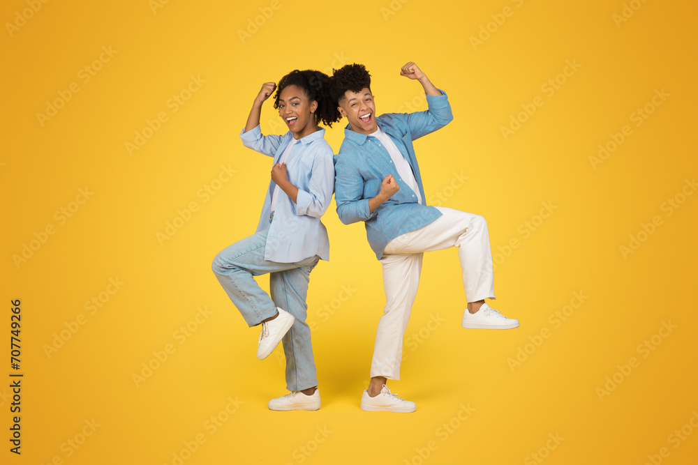 Cheerful young african american guy and woman in casual celebrate win, success Cheerful young african american guy and woman in casual celebrate win, success