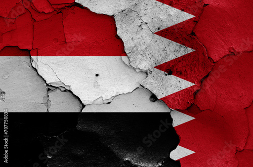 flags of Yemen and Bahrain painted on cracked wall