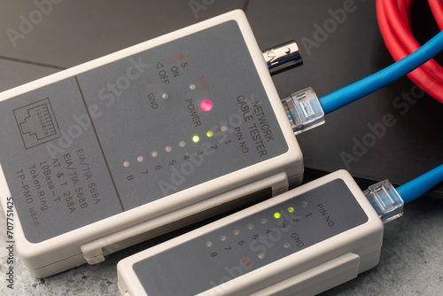 Checking the integrity of computer wires with a network cable tester, close-up of a LAN tester