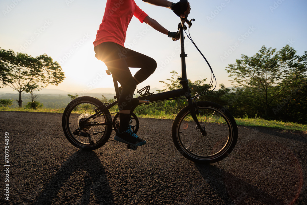 Riding folding bike on sunny mountain top road Riding folding bike on sunny mountain top road