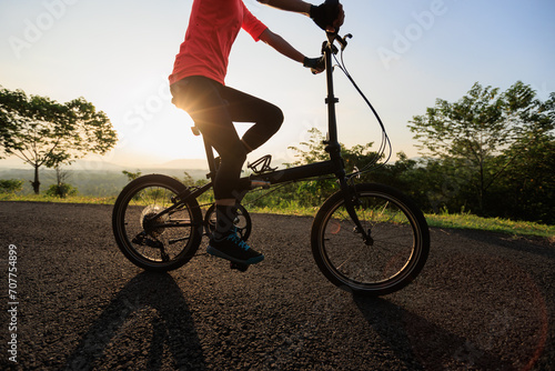 Riding folding bike on sunny mountain top road © lzf