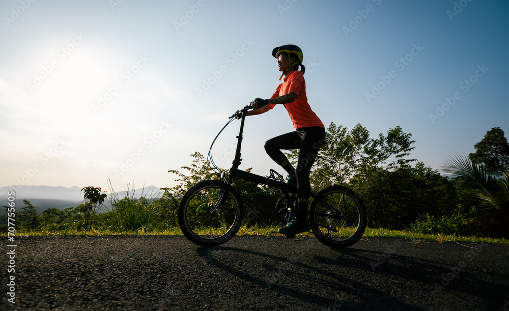 Riding folding bike on sunny mountain top road Riding folding bike on sunny mountain top road