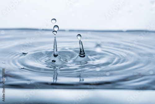 Captivating water droplet creating intriguing splash on white background. Perfect for banners, advertising, and visual merchandising
