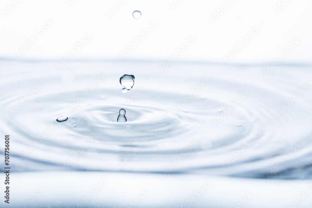 Captivating water droplet creates intriguing shapes, generating motion and splashes against a pristine white backdrop. Ideal for banners promoting freshness or hydration. Captivating water droplet creates intriguing shapes, generating motion and splashes against a pristine white backdrop. Ideal for banners promoting freshness or hydration.