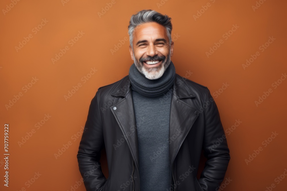Portrait of a happy middle-aged man in a black leather jacket on a brown background Portrait of a happy middle-aged man in a black leather jacket on a brown background