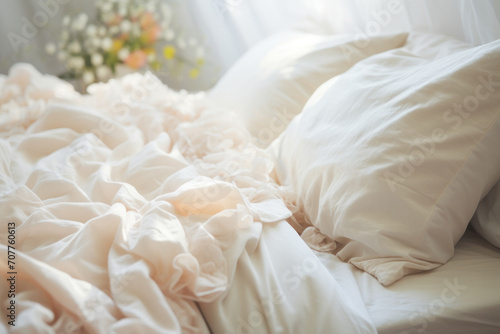 A messy, comfortable bed with soft pillows and crumpled white sheets in a cozy bedroom.