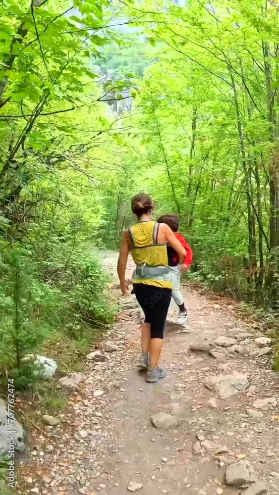 Mother with her son on trekking walking at waterfall in Theth national park, Albania Mother with her son on trekking walking at waterfall in Theth national park, Albania