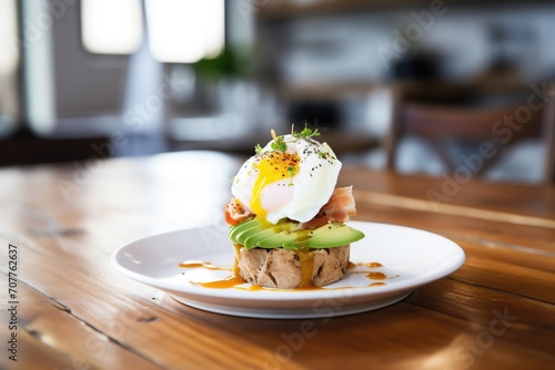 muffin with poached egg and avocado slices on top