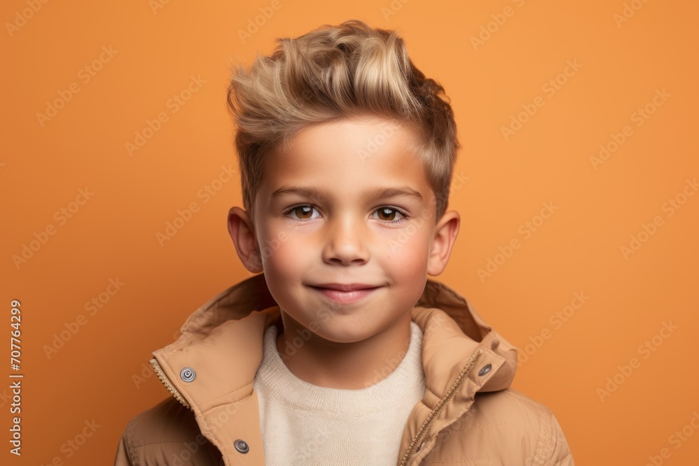 portrait of smiling little boy in beige jacket over orange background portrait of smiling little boy in beige jacket over orange background