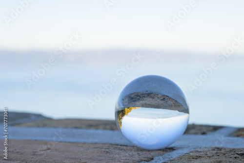 Fototapeta Naklejka Na Ścianę i Meble -  Glass ball lying on a stone wall