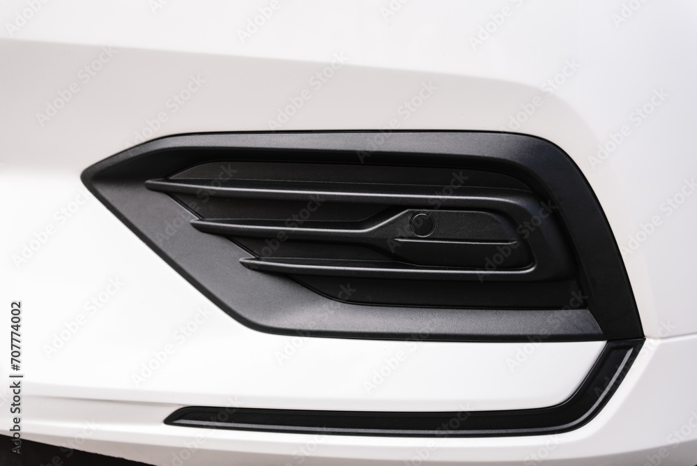 Front right parktronic on a modern white new car. Detail metallic bumper car. Exterior automobile closeup. Front right parktronic on a modern white new car. Detail metallic bumper car. Exterior automobile closeup.