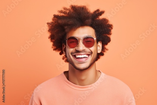 Cheerful young African American man isolated on beige background.
