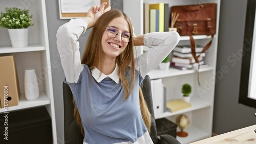 Playful, attractive blonde businesswoman doing crazy bull horns gesture with fingers on head at the office, showcasing fun yet serious side photo