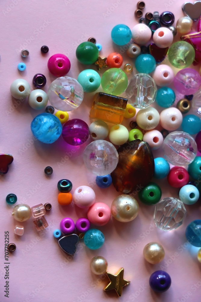Various colorful beads on bright pink background. Top view. Various colorful beads on bright pink background. Top view.
