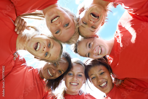 Team, women and smile with sport huddle for support, celebration or solidarity with blue sky and low angle. Collaboration, athlete and people or happy in circle for fitness, exercise and competition