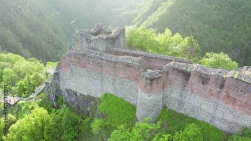 Poenari fortress in Romania. Aerial 4k video with this amazing fortress on top of a peak hill from Fagaras Mountains, the place where Vlad Dracula lived. Travel to Romania landmarks. Sunset sky. photo