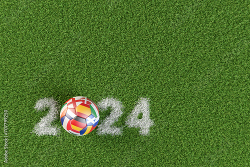 Soccer ball with the flags of several of the countries qualified for the European Championship in 2024 in Germany. The year 2024 displayed as chalk marking in the grass.