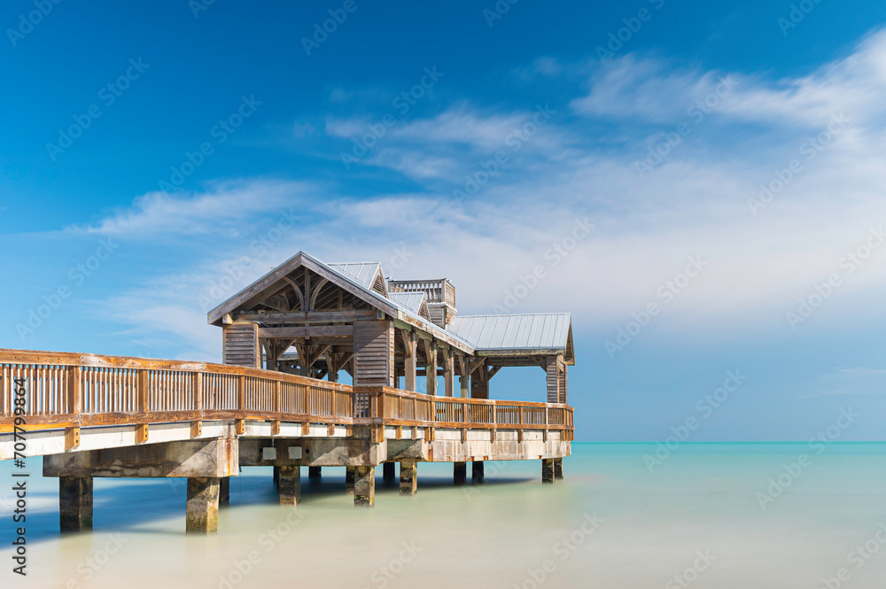 Wooden pier, located in Key West, Florida, reaching out into the calm tropical waters of the turquiose ocean, on a sunny, summers day