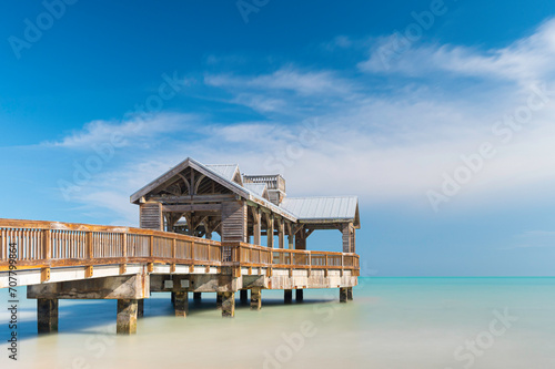 Wooden pier, located in Key West, Florida, reaching out into the calm tropical waters of the turquiose ocean, on a sunny, summers day photo