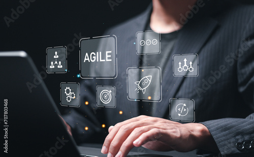 Agile development methodology, businessman use laptop with virtual screen of agile icons for process that will help you work faster By reducing step-by-step work and focusing on team communication. photo