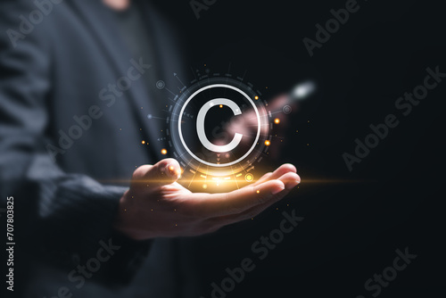 Patented patent copyright law business technology concept. businessman holding virtual copyright symbol for author rights and patented intellectual property.