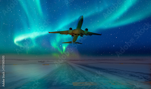 Commercical white airplane fly up over take-off runway the (ice) snow-covered airport with aurora borealis - Norway photo