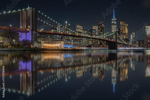 view of the brooklin bridge at night with reflections. manhattam skyline, brooklyn bridge. New York City photo