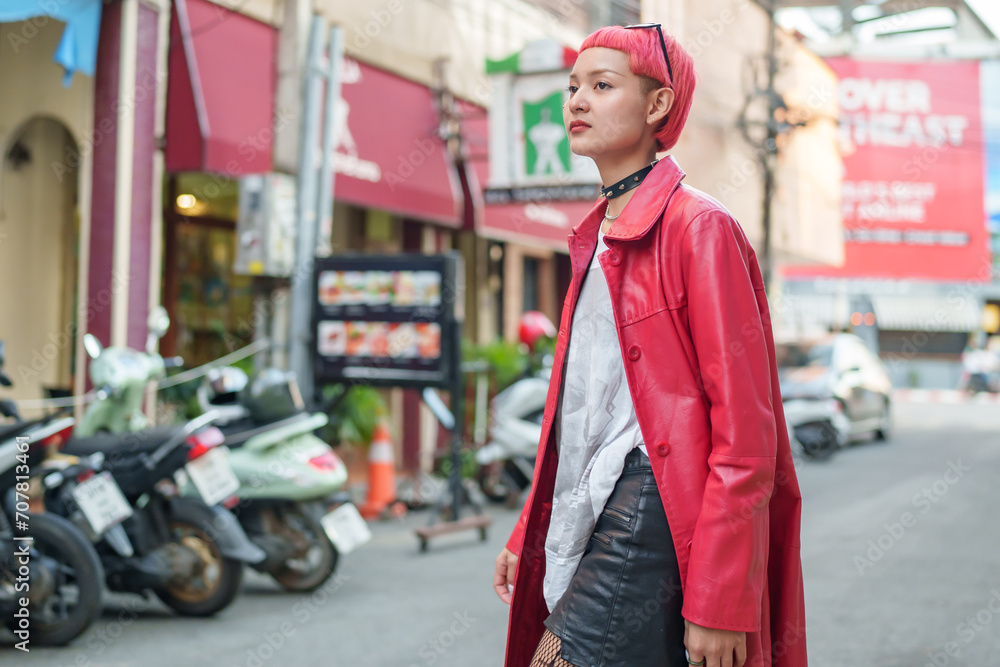 Gen z girl leather fashion with punk Asian woman tourist of local city Southeast Asia travel trendy pink hairstyle young female punk traveler walking around in town