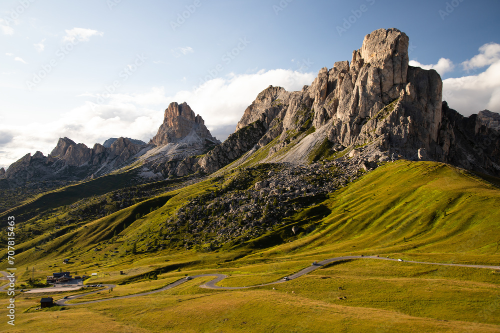 View of Ra Gusela mountain with green meadows and blue sky, Dolomites, Italy