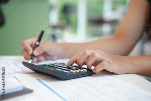 Businesswoman Accountant analyzing investment charts Invoice and pressing calculator buttons over documents. Accounting Bookkeeper Clerk Bank Advisor And Auditor Concept.